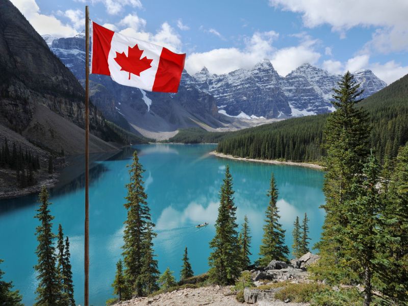 Kanada – ciekawostki o sąsiedzie USA. NA zdjęciu jezioro, nad którym wisi flaga Kanady.