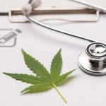 Marihuana medyczna – stary-nowy trend w leczeniu. Na zdjęciu liść marihuany i stetoskop.