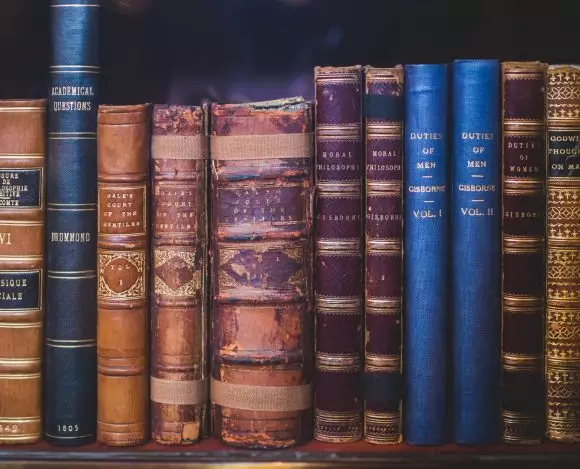 Na półce ułożone są stare książki opisujące epoki historyczne.