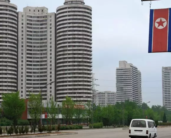 Jak wygląda życie w Korei Północnej? Na zdjęciu flaga kraju, a w tle Pjongczang, czyli stolica państwa.